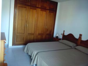 sypialnia z łóżkiem i drewnianymi szafkami w obiekcie Apartamentos Mary w mieście Fuengirola