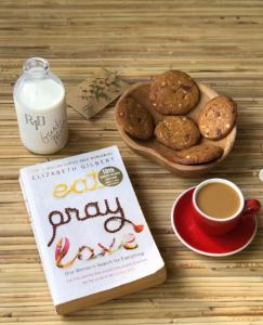 a book and a plate of cookies and a cup of coffee at Liyer Spirit House in Ubud