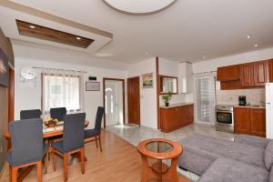 a kitchen and living room with a table and a couch at Apartments Liljana Privlaka in Privlaka