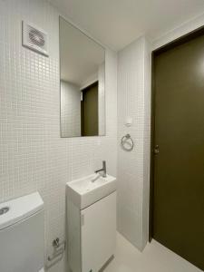 een badkamer met een wastafel, een spiegel en een toilet bij Sweet Love Family III in Coimbra
