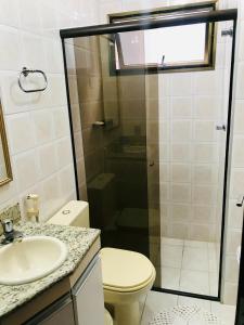 a bathroom with a shower and a toilet and a sink at Lindo apartamento 200 metros da praia! in Ubatuba