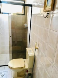 a bathroom with a toilet and a shower at Lindo apartamento 200 metros da praia! in Ubatuba