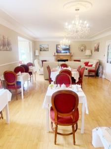 a dining room with tables and chairs and a chandelier at Rockfield Manor B&B, Knock in Knock