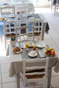 uma mesa com pratos de comida e fruta em Hôtel Les Mimosas em Argelès-sur-Mer