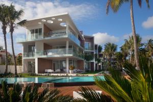 a large white house with a pool and trees at Ultravioleta Boutique Residences in Cabarete