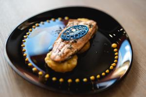 a black plate with a piece of food on it at Hotel Touring in Predazzo