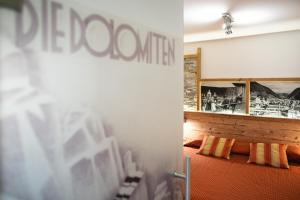 uma vista para um quarto com uma parede com um espelho em Hotel Touring em Predazzo