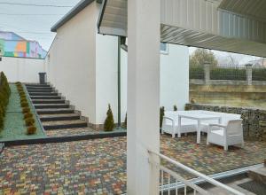 a patio with a white table and chairs and stairs at White House in Truskavets