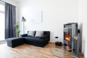 sala de estar con sofá negro y chimenea en Zentrales & modernes City-Apartment, en Graz