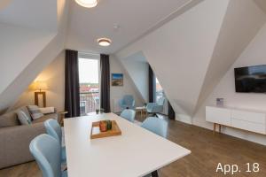 uma sala de estar com uma mesa branca e um sofá em Luxe 6-persoons appartement em Zoutelande