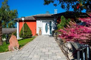 a house with a white door and a brick driveway at Villa Croatia & Restaurant Adria in Klingenberg am Main