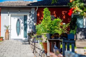 uma casa com uma porta branca com plantas em Villa Croatia & Restaurant Adria em Klingenberg am Main