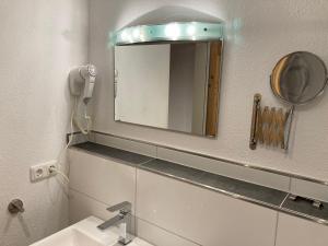 a bathroom with a mirror and a sink at Ferienwohnung Familie Zuck in Missen-Wilhams