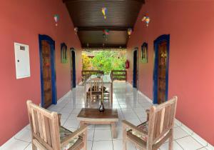 a dining room with red walls and chairs and tables at Pousada Manaca in Paraty