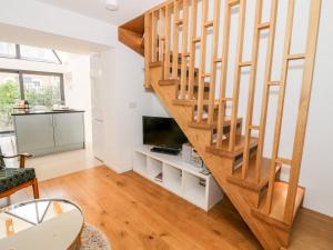 a living room with a wooden staircase and a television at Little Mornington in Malvern Link