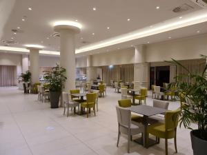 a restaurant with tables and chairs and plants at Nissiana Hotel & Bungalows in Ayia Napa