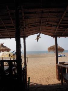 a view of a beach with a star hanging from a straw umbrella at Hare's BAR AND RESTAURANT in Canacona