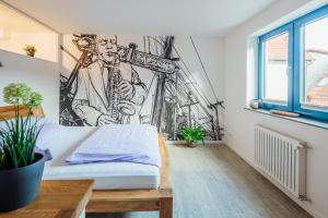 Zimmer mit einem Bett und Wandgemälde in der Unterkunft Aparthotel Pumpengasse in Wolfsburg