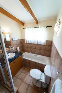 ein Badezimmer mit Toilette, Badewanne und Waschbecken in der Unterkunft Gooderson Monks Cowl Golf Resort in Champagne Valley