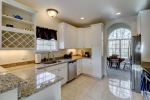 Una cocina grande con gabinetes blancos y una mesa. en Wonderful luxury pet friendly home in Shipyard with great golf Bikes & Beach Gear included, en Hilton Head Island