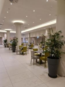 a restaurant with tables and chairs and potted plants at Nissiana Hotel & Bungalows in Ayia Napa