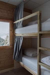 um quarto com beliches num camarote com uma janela em BodyGo Hostel em Valfréjus