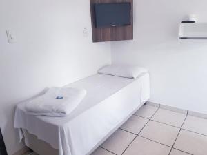Habitación con cama y TV en la pared. en Hotel Salto do Norte, en Blumenau
