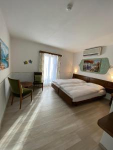 Schlafzimmer mit einem Bett, einem Schreibtisch und einem Stuhl in der Unterkunft Hotel Antico in Intragna