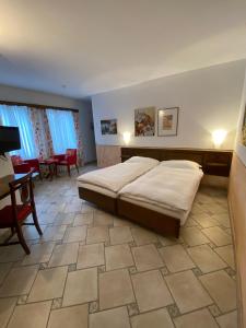 Schlafzimmer mit einem Bett, einem Tisch und Stühlen in der Unterkunft Hotel Antico in Intragna