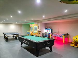 a room with a ping pong table and a room with a video game at Nissiana Hotel & Bungalows in Ayia Napa