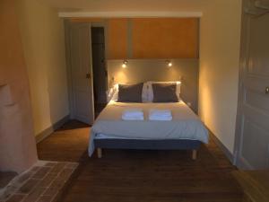 een slaapkamer met een bed met twee handdoeken erop bij Chambres d'hôtes L'Epicurium in Le Puy en Velay