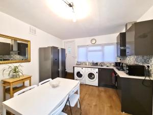 een keuken met een witte tafel en een wit aanrecht bij Grace Apartments - Living Stone 2 in Ashford