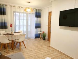 Televízia a/alebo spoločenská miestnosť v ubytovaní Apartamento Guardamar Playa