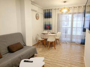 salon z kanapą, stołem i krzesłami w obiekcie Apartamento Guardamar Playa w mieście Guardamar del Segura