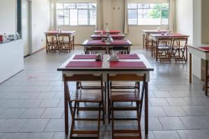 uma fila de mesas numa sala de jantar com mesas vermelhas em Piúma Palace Hotel em Piúma