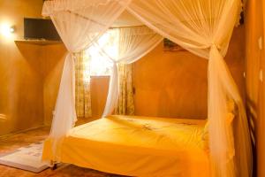 a bedroom with a canopy bed with a window at Villa Paradis in Sainte Marie