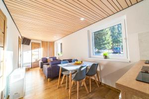 a kitchen and living room with a table and chairs at Chata Claudia in Belá