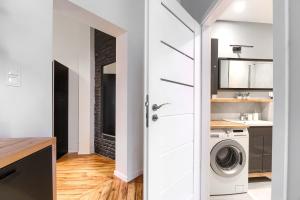 a laundry room with a washer and dryer at MARGI Martini BIG BEAUTI STUDIO in Szczecin