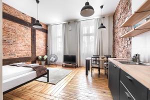 a kitchen and living room with a brick wall at MARGI Martini BIG BEAUTI STUDIO in Szczecin