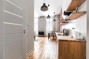 a kitchen with wooden floors and white walls and wooden counters at MARGI Martini BIG BEAUTI STUDIO in Szczecin