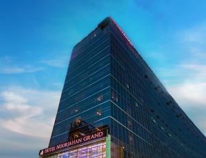 un edificio de cristal alto con un cartel. en Hotel Noorjahan Grand, en Sylhet