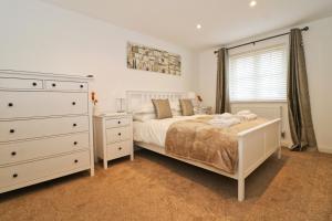A bed or beds in a room at NEAR BEACHES, contemporary home in village centre