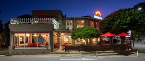 un restaurante con sombrillas rojas frente a un edificio en Hotel Arcoiris, en Villa Gesell