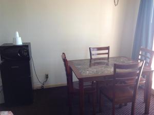 einen Esstisch mit Stühlen, einem Tisch und einer Mikrowelle in der Unterkunft Sea Shell Inn on the Beach in Corpus Christi