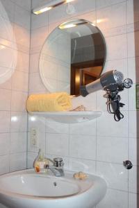 La salle de bains est pourvue d'un lavabo, d'un sèche-cheveux et d'un miroir. dans l'établissement Hotel Gasthaus Zur Linde, à Glottertal