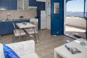 a kitchen with blue cabinets and a table and chairs at Milos Sunset Home in Tripiti +21 photos