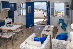 a kitchen and a living room with a table and chairs at Milos Sunset Home in Tripiti