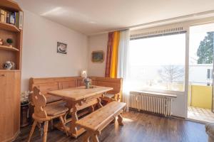 ein Esszimmer mit einem Holztisch und einem Fenster in der Unterkunft Toni in Lindau