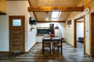 a kitchen and dining room with a table and chairs at Apartament Zagroda in Czarny Dunajec
