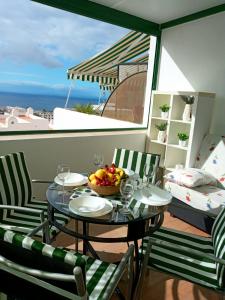 a table with a bowl of fruit on a balcony at MNG-Apart Aloha Garden Costa Adeje in Adeje